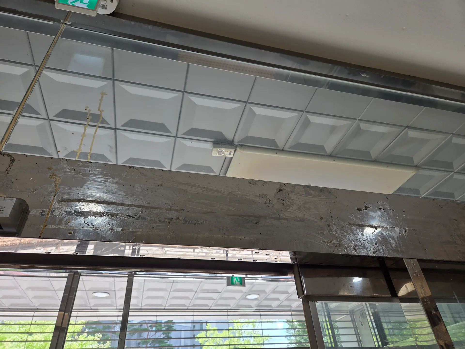 스테인리스 상부 프레임에 길고 평평한 띠 형태의 잔여물이 남은 구간