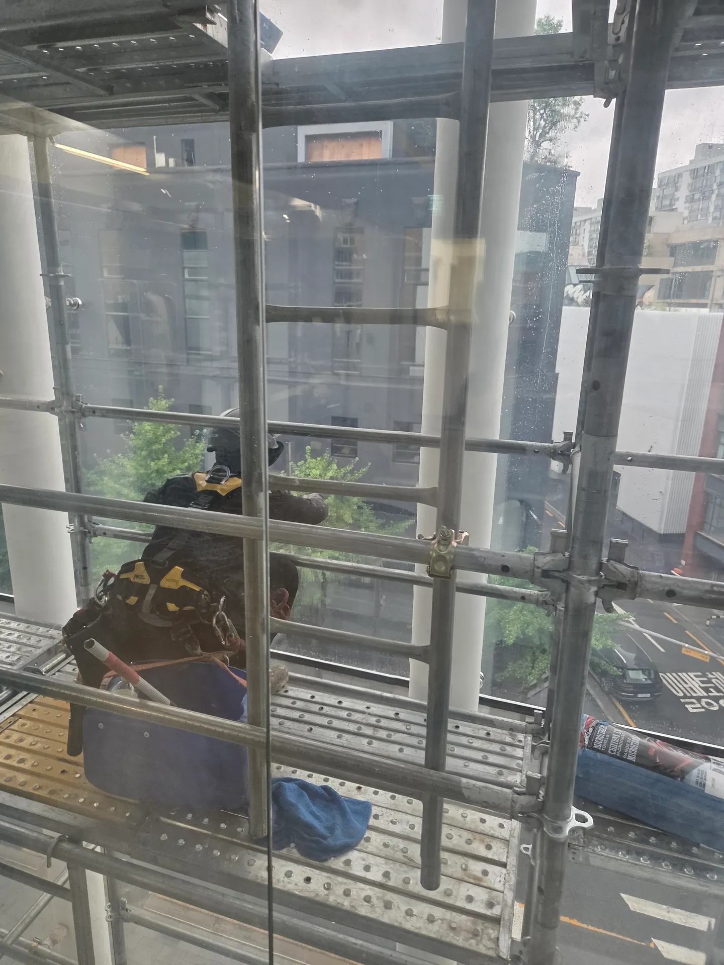 외부 골조 안쪽에서 물방울이 퍼진 통유리 표면을 가까이 본 모습