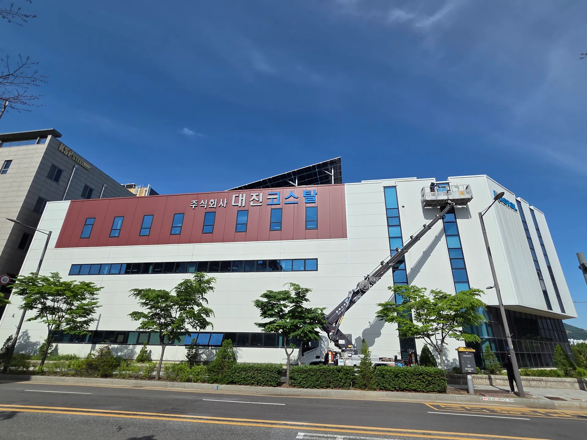 외벽 패널과 세로창과 격자 유리의 구성이 함께 보이는 산업건물
